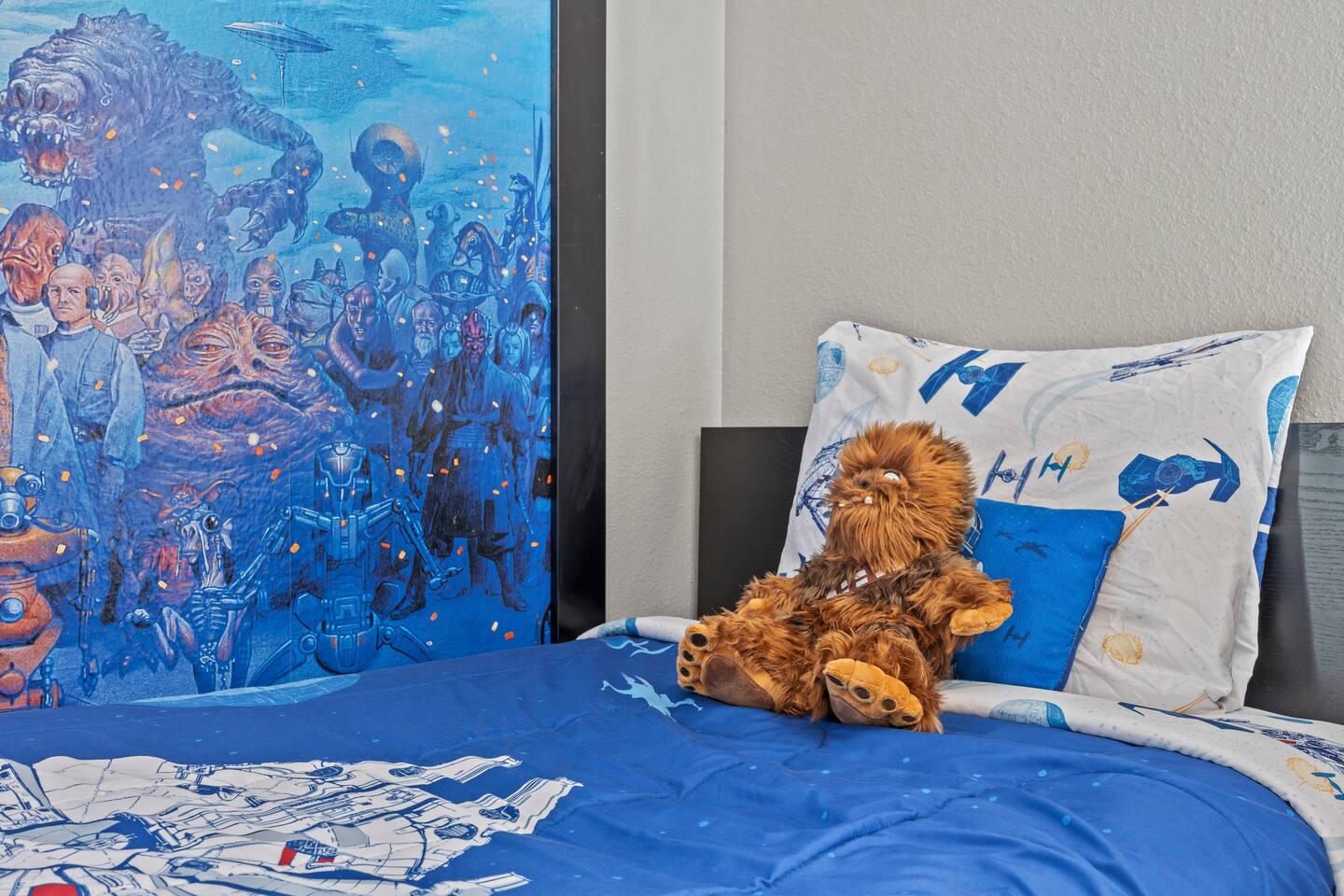 Star Wars bed close-up with plush Chewbacca, starship pillowcases, and mural det