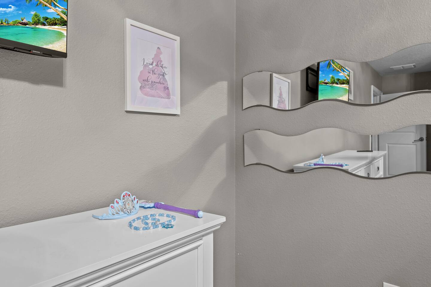 Princess room dresser with play tiara and wand set beneath wave-shaped mirrors a