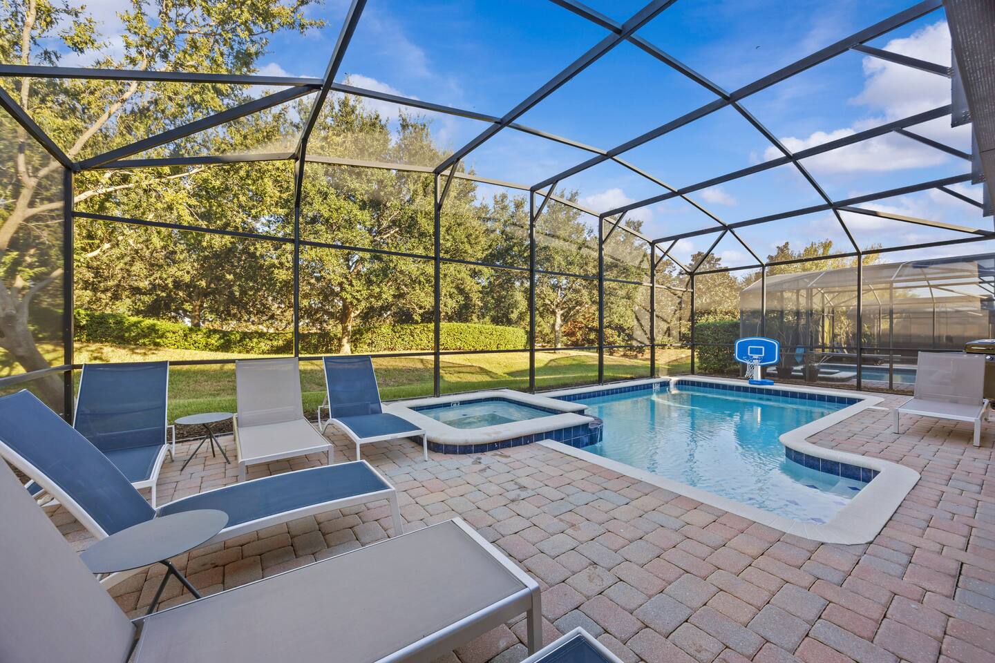 Screened private pool and raised spa with sun loungers and poolside basketball h