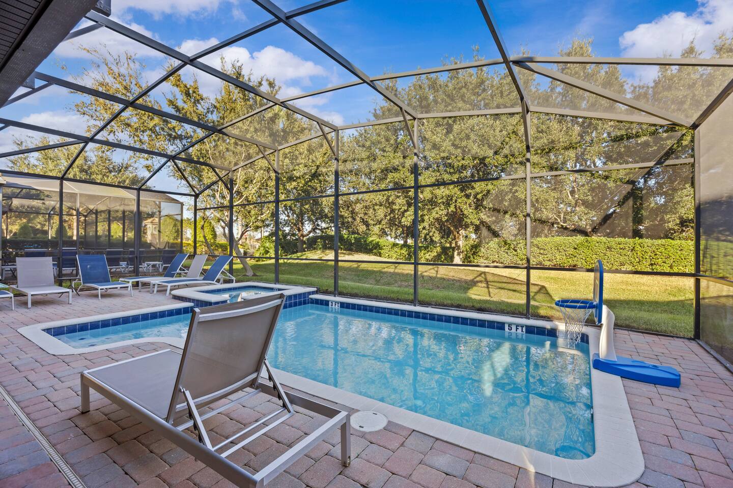 Private pool with loungers, basketball hoop, and depth markers inside the screen