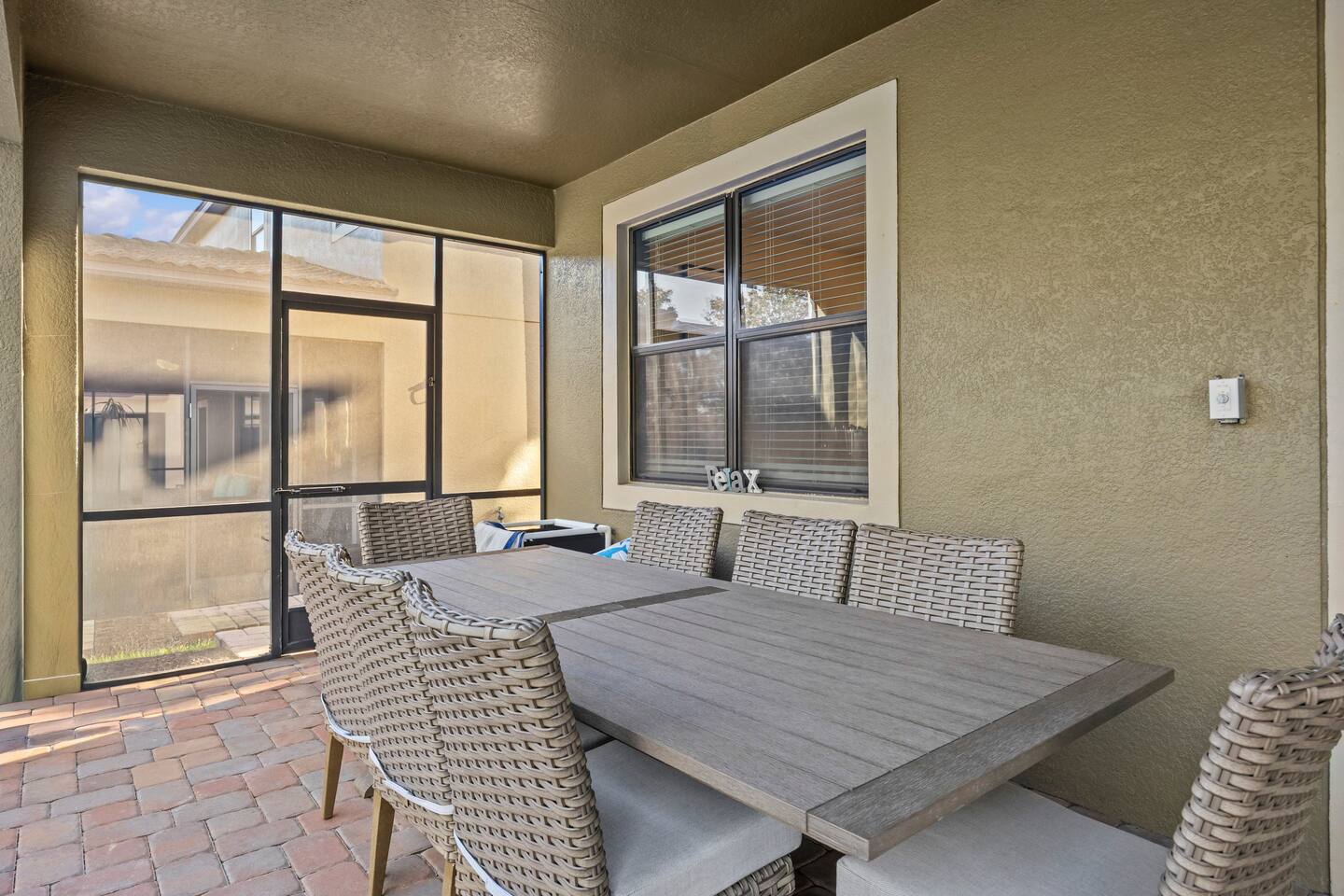 Covered lanai with outdoor dining table and wicker chairs