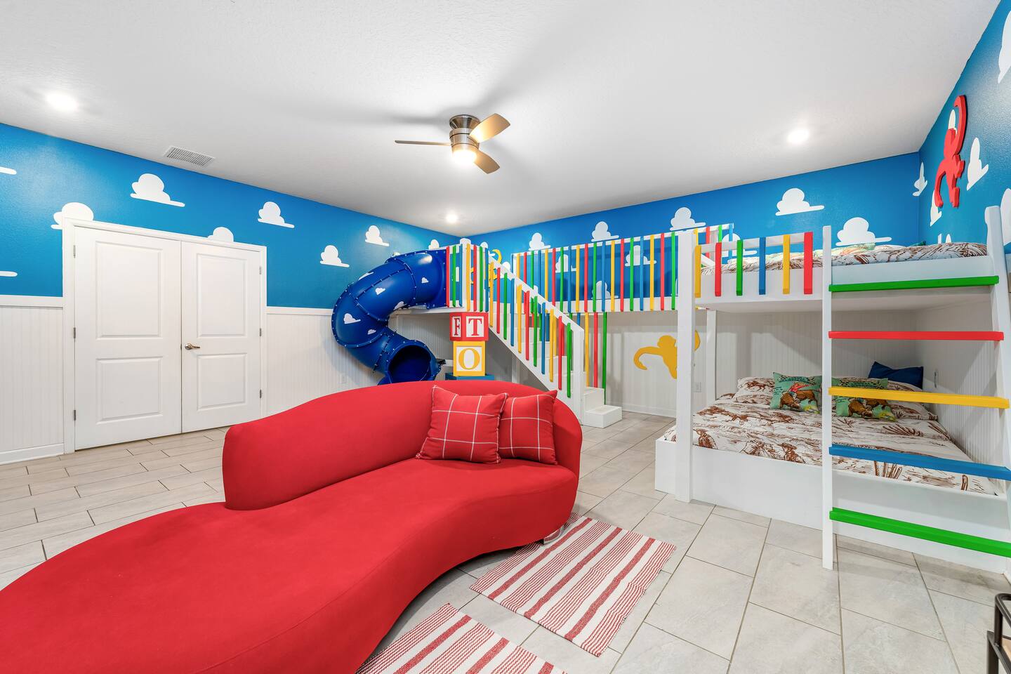 Toy Story bunk room with slide, red lounge sofa, and bunk beds