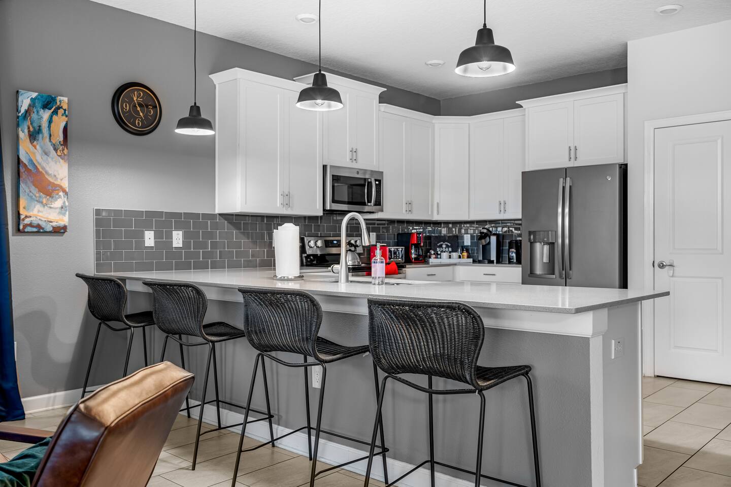 Kitchen breakfast bar with four stools and stainless appliances
