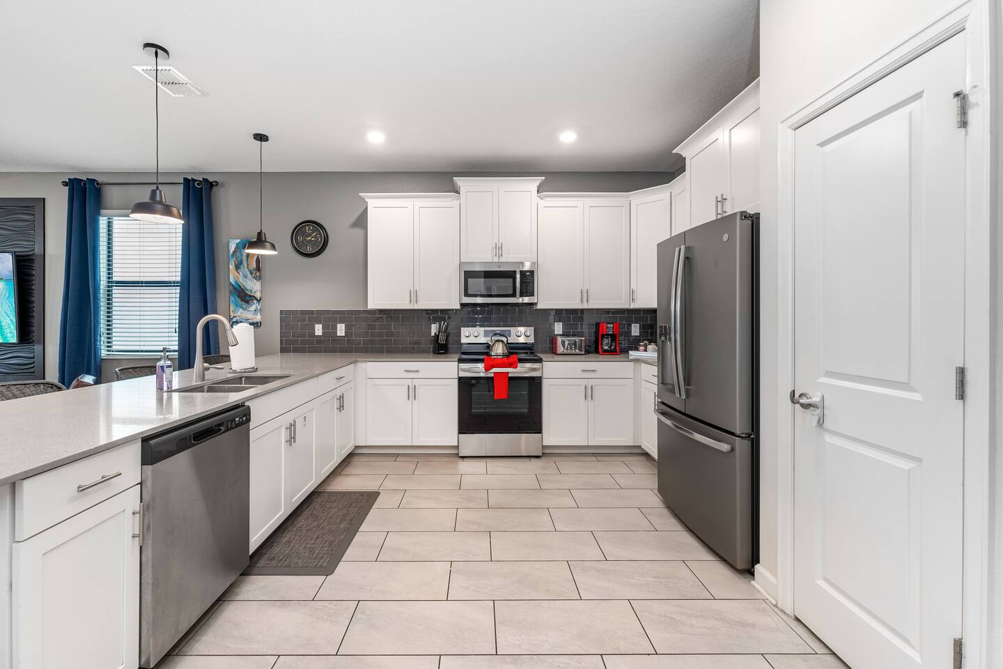 Full kitchen with white cabinets, stainless appliances, and tile floors