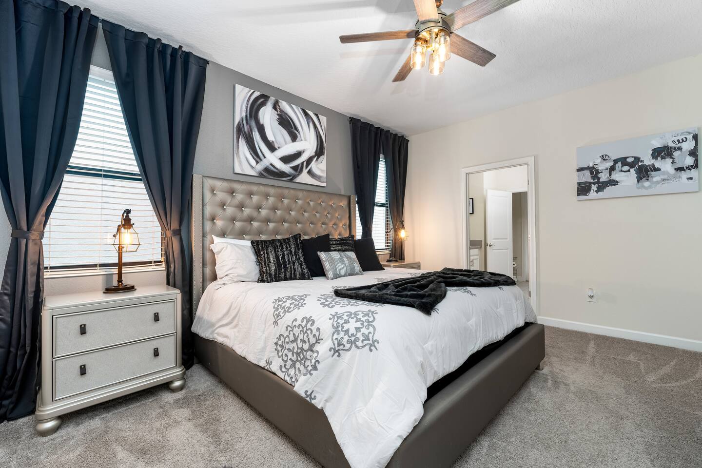 King bedroom with tufted headboard and black and white decor