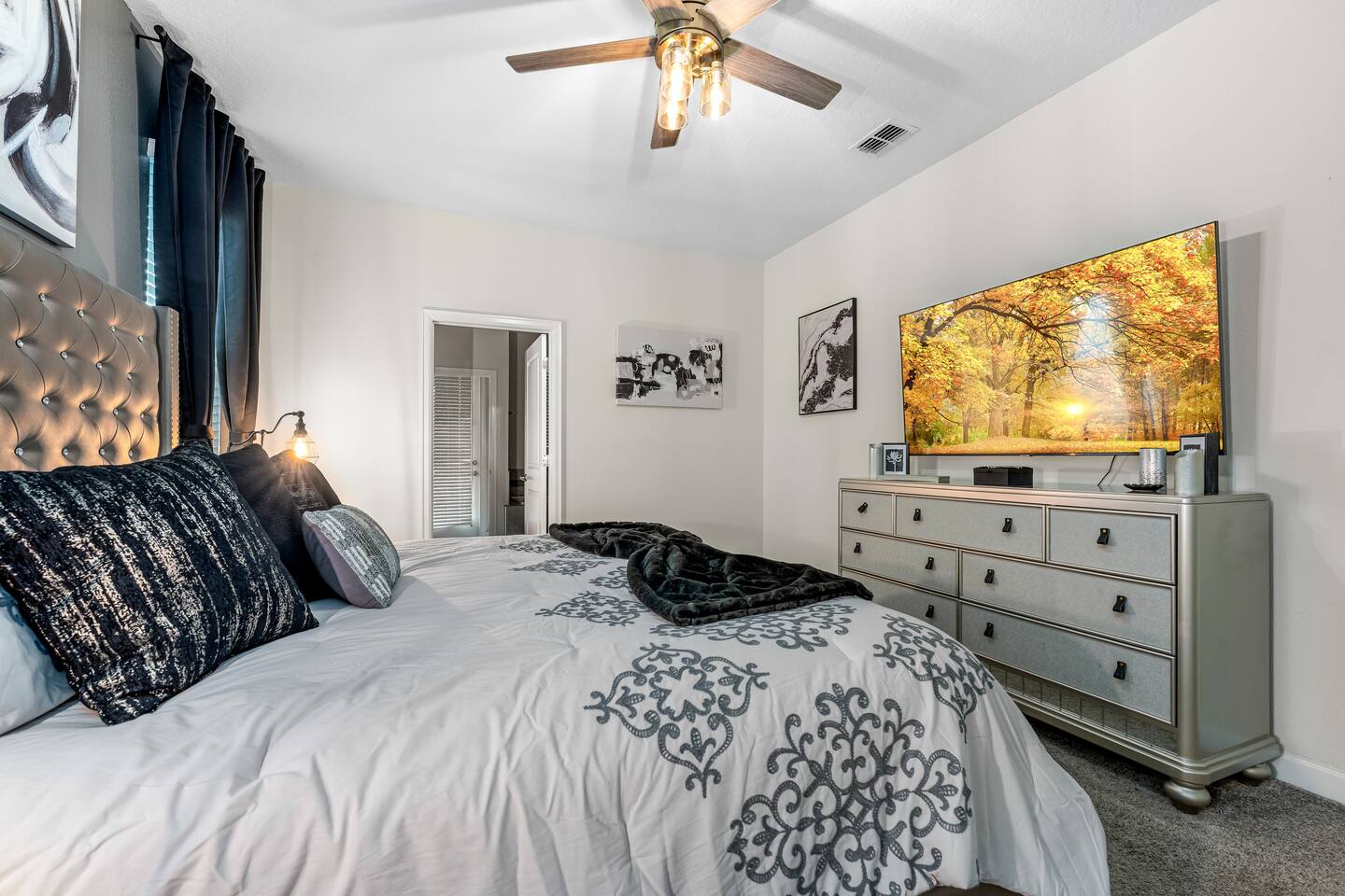 King bedroom with dresser and wall-mounted flat-screen TV