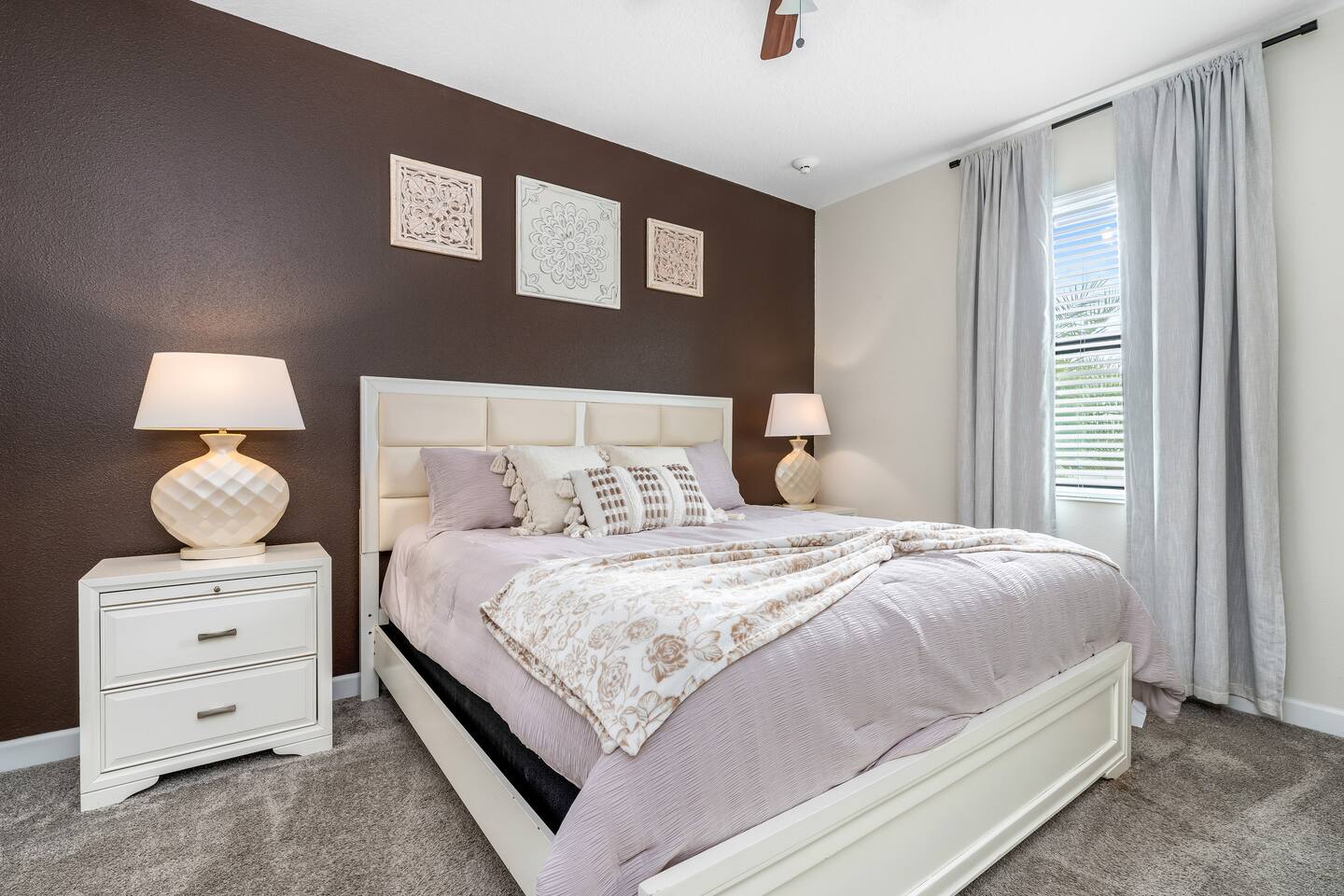 King bedroom with brown accent wall and lavender bedding