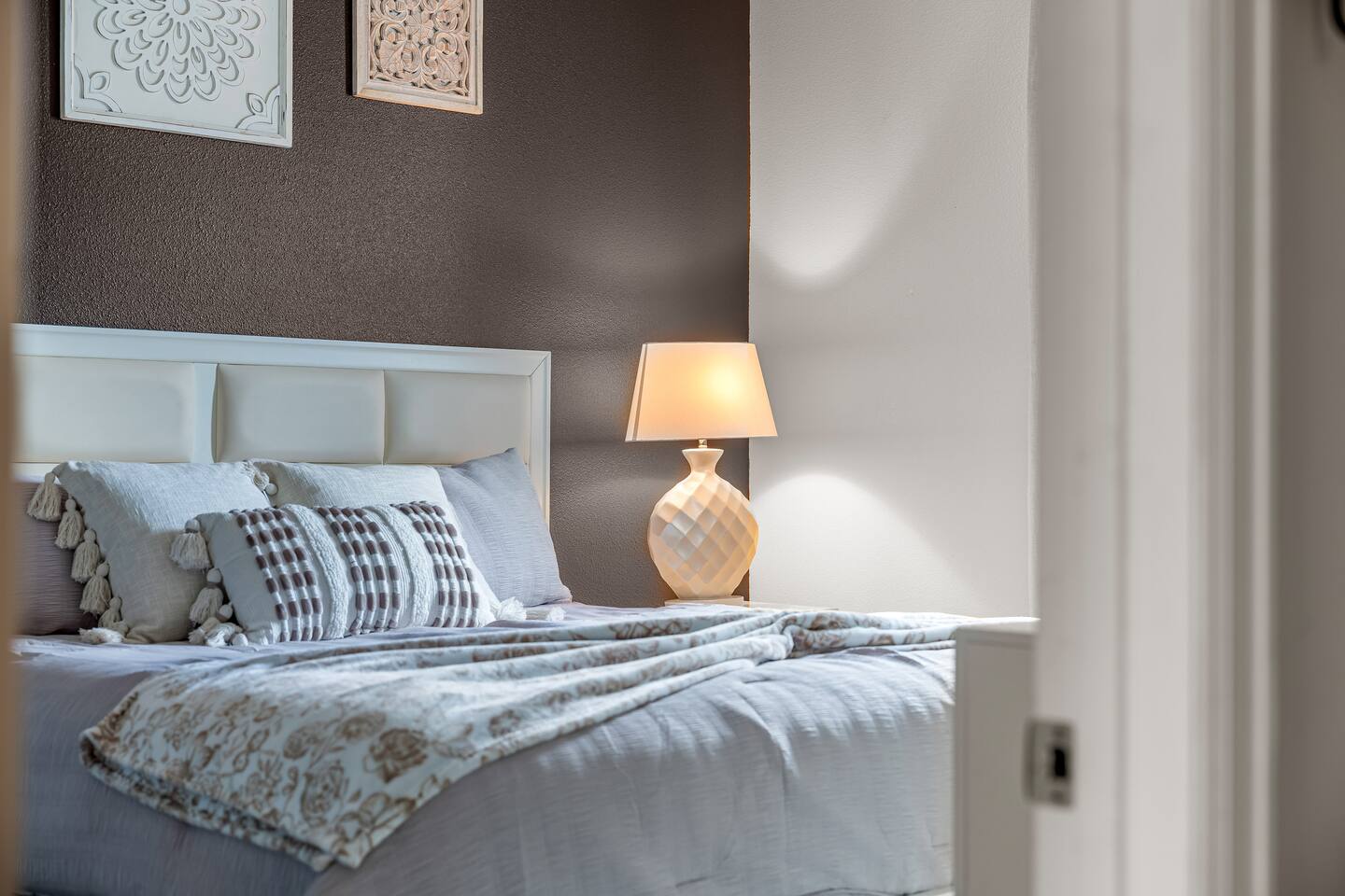 Bedside detail with lamp and layered pillows