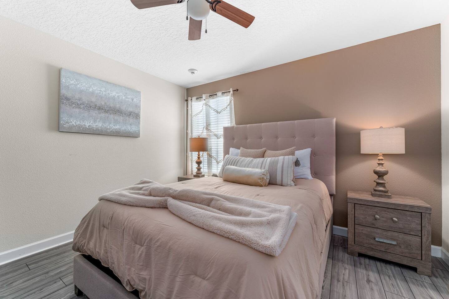 Queen bedroom with taupe accent wall and tufted headboard