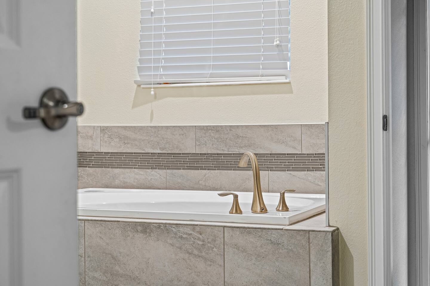 Master Bathroom Oasis: Unwind in this stylish tub, bathed in natural light and s