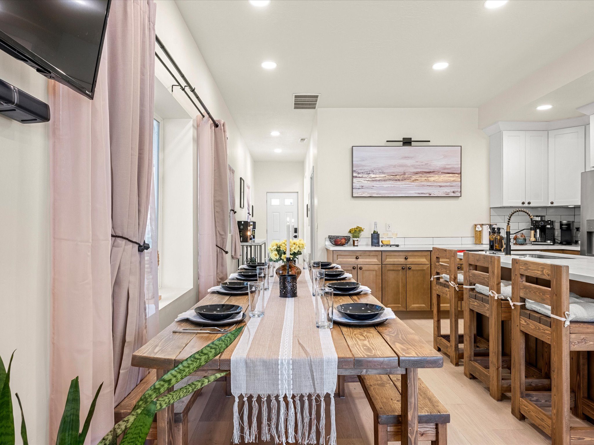 Farmhouse dining table and bar seating leading into the kitchen