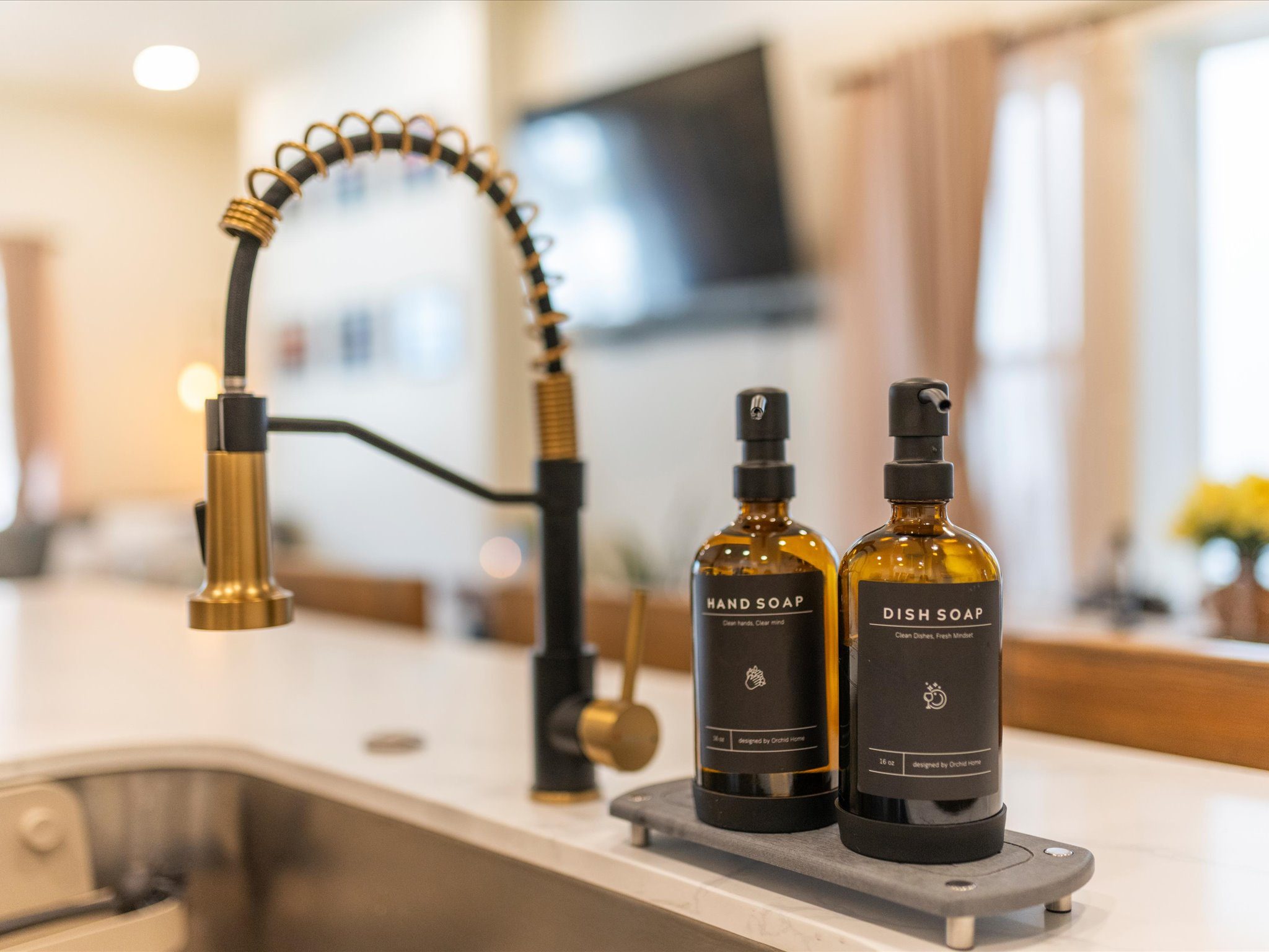 Kitchen sink with a pull-down faucet and refillable soap dispensers