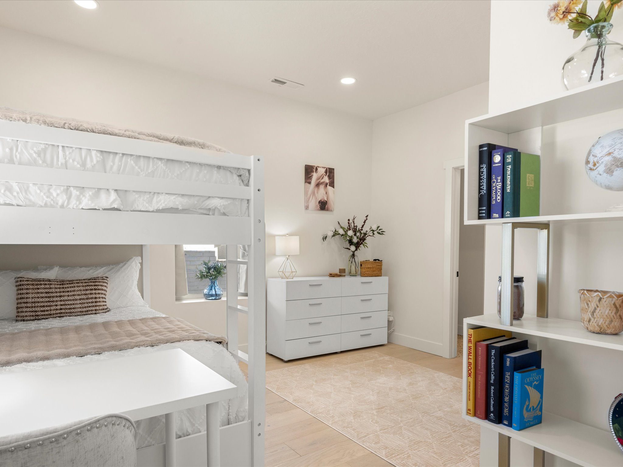 Bunk room with a dresser, bookshelf, and horse artwork