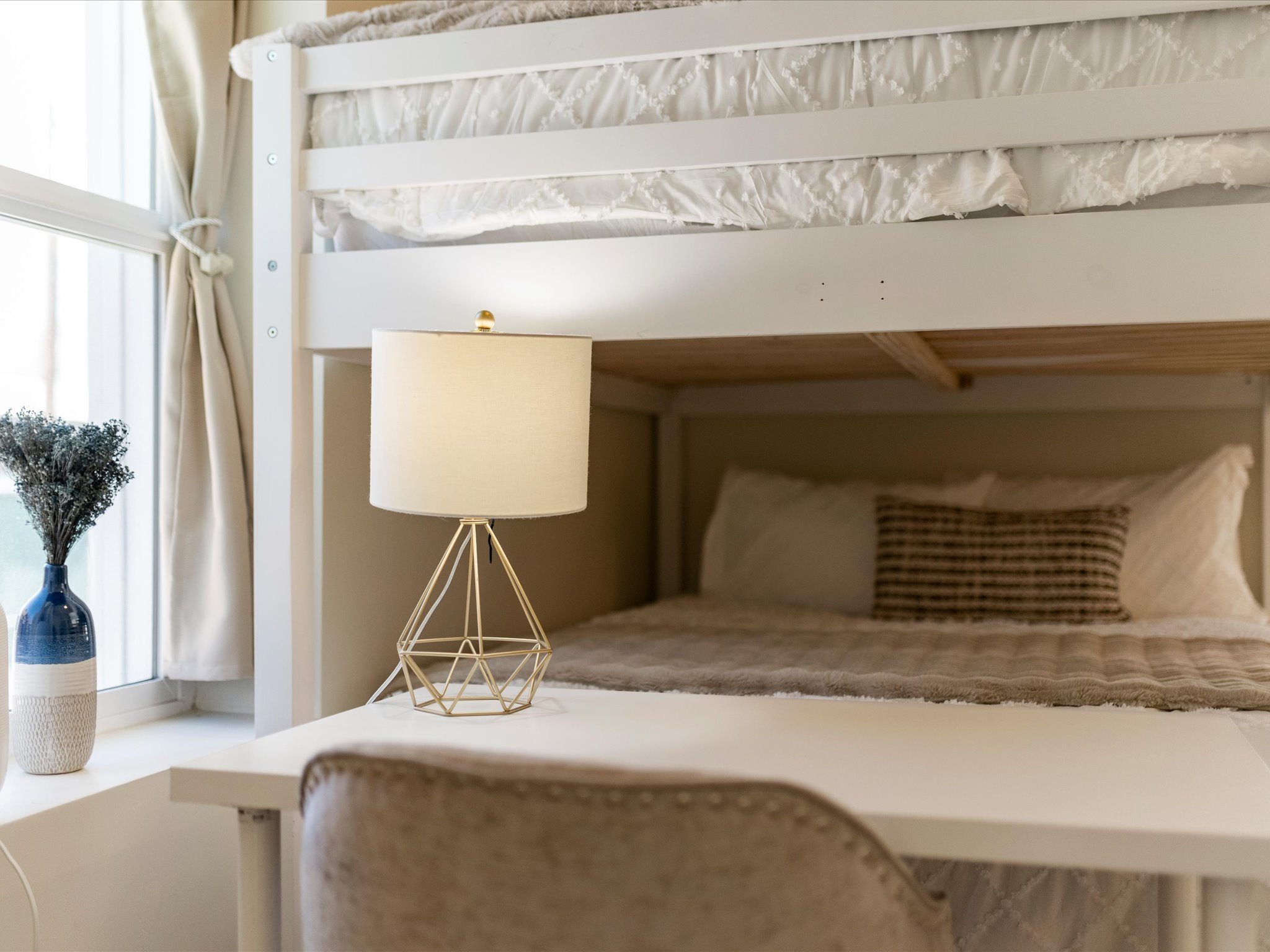 Lower bunk with a reading lamp and built-in desk