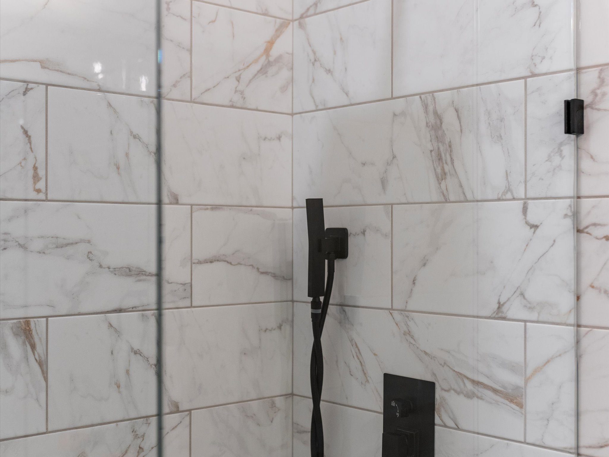 Marble shower with handheld and rainfall fixtures