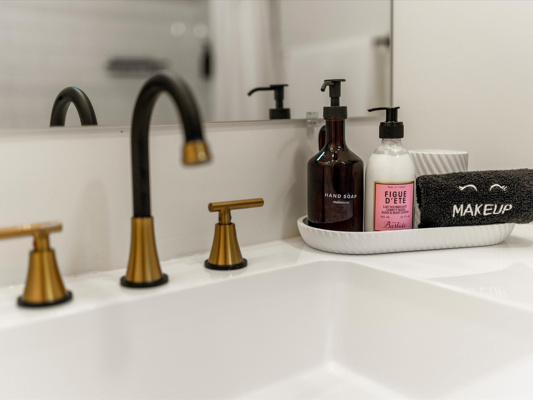 Vanity detail with hand soap, lotion, and a makeup cloth