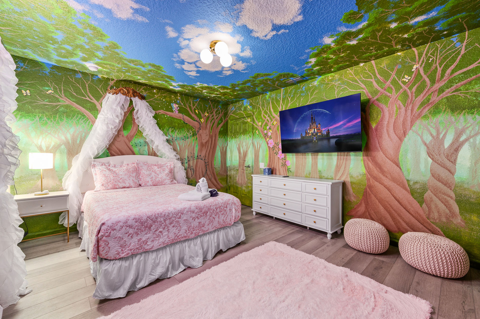 The fairytale room's painted forest wraps the walls and ceiling — with its own w