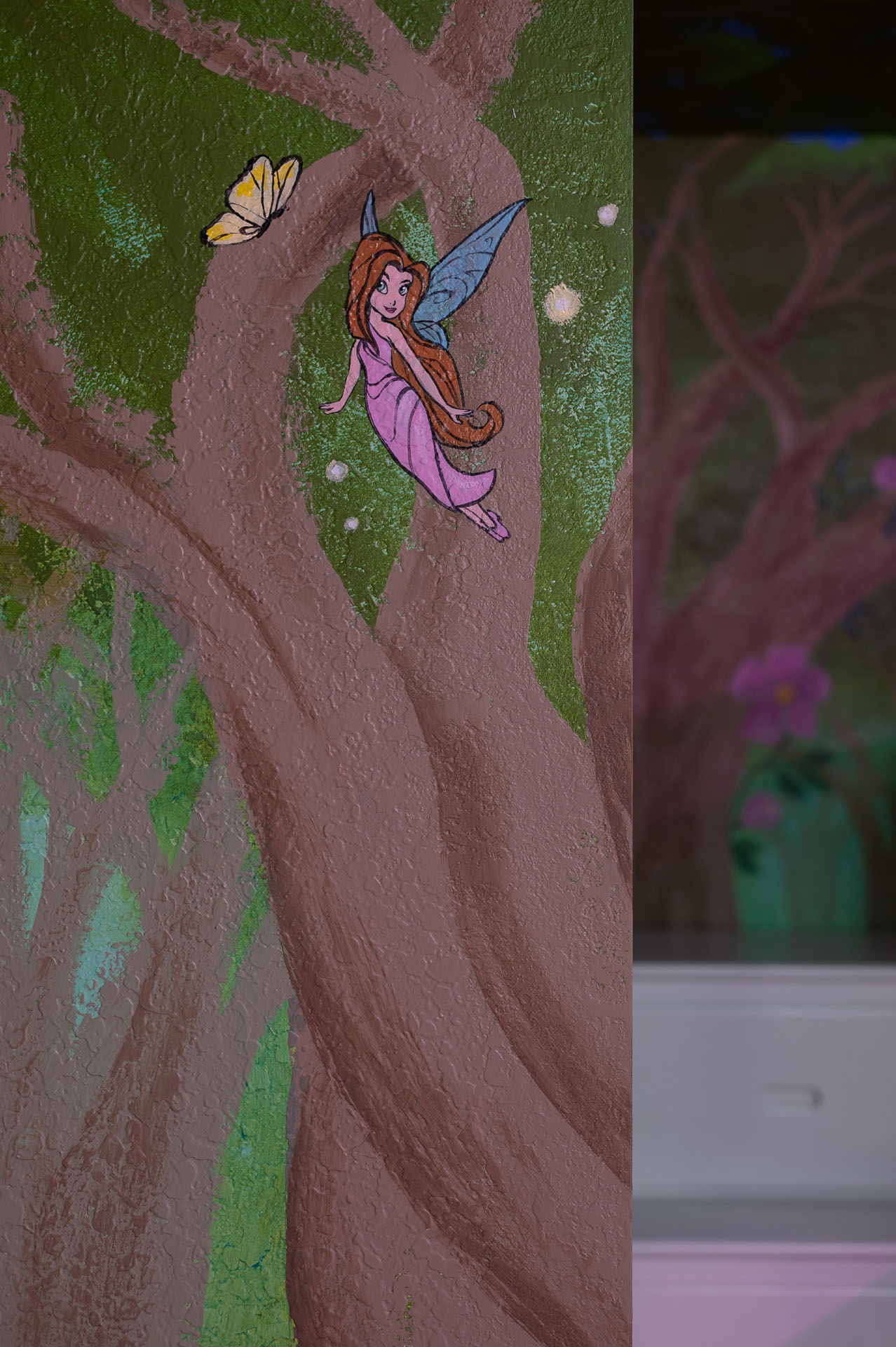 Hand-painted fairy and butterfly details in the fairytale bedroom mural.