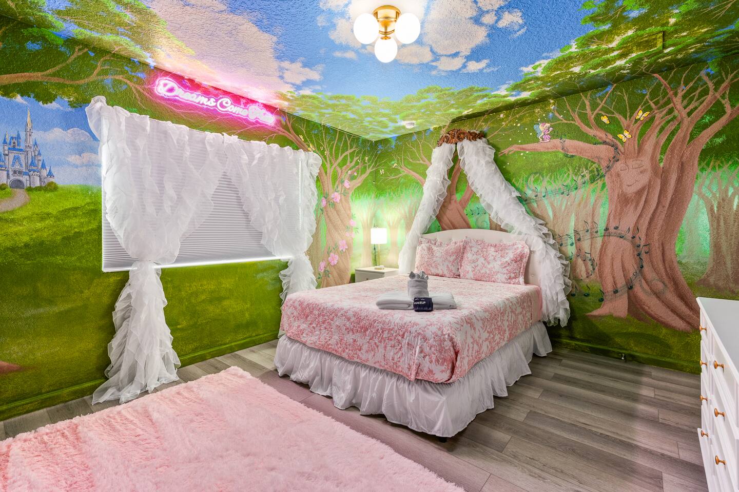Queen bed with a ruffled canopy beneath the fairytale room's painted sky.