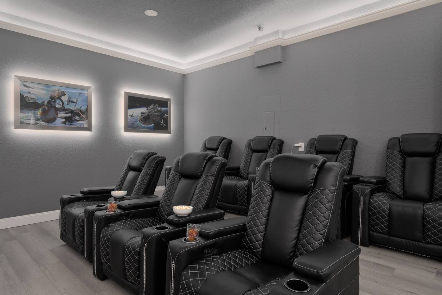 Plush theater recliners with cup holders — popcorn ready.