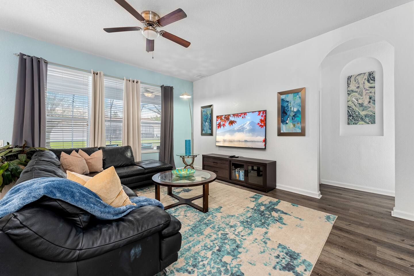 Family room with a leather sectional and wall-mounted TV.