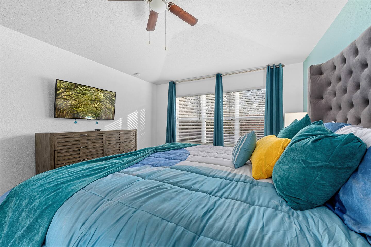 Owner's suite TV and dresser opposite the king bed.