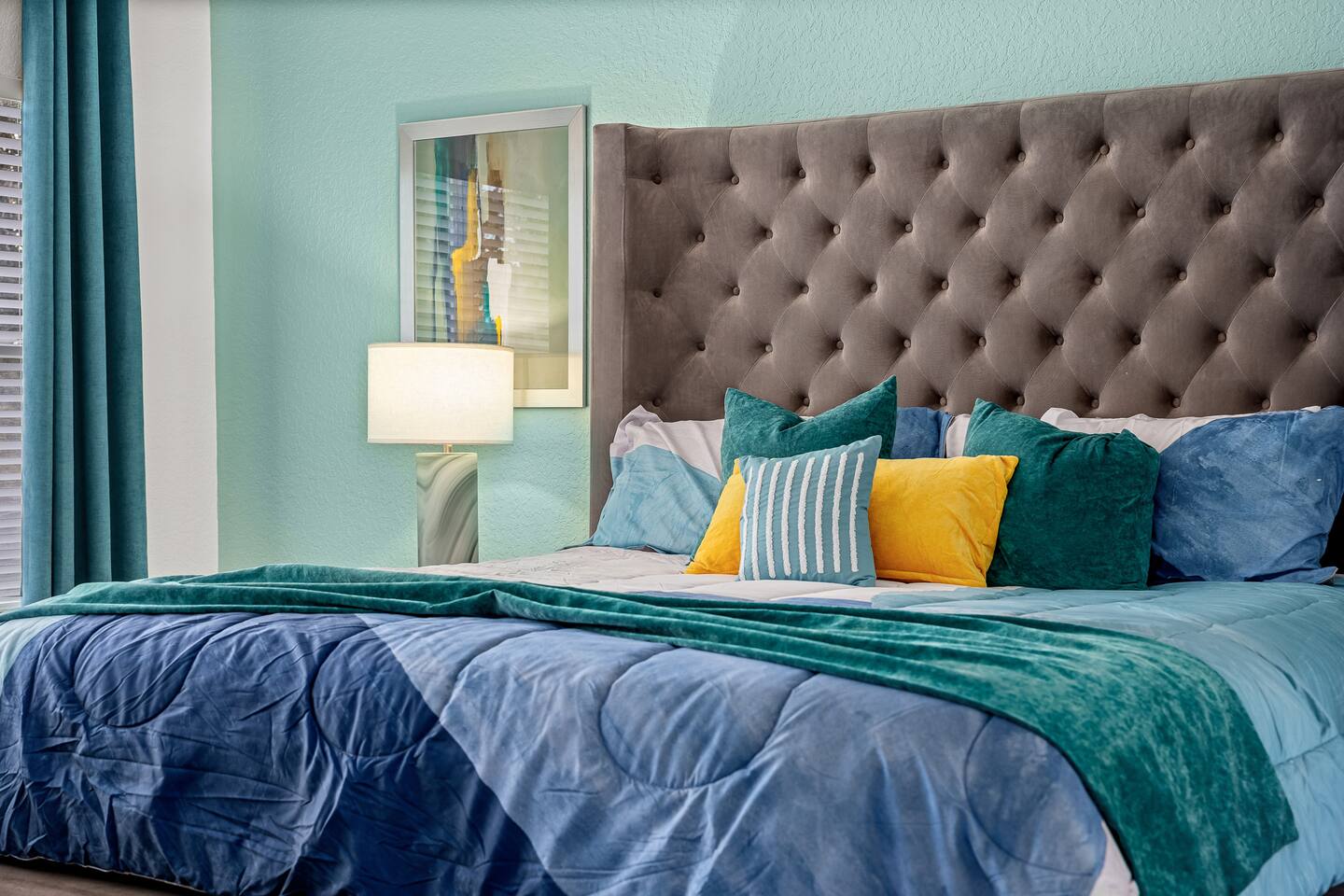 Tufted velvet headboard and layered pillows in the owner's suite.