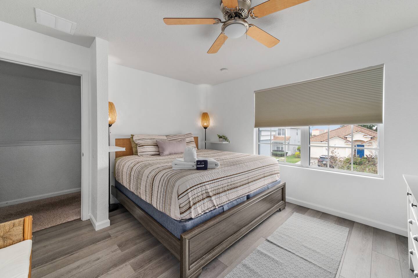 King bedroom with warm boho styling and cellular blackout shades.