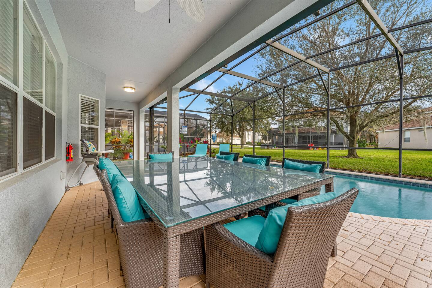 Covered lanai dining table seats eight, with a high chair for the littlest guest