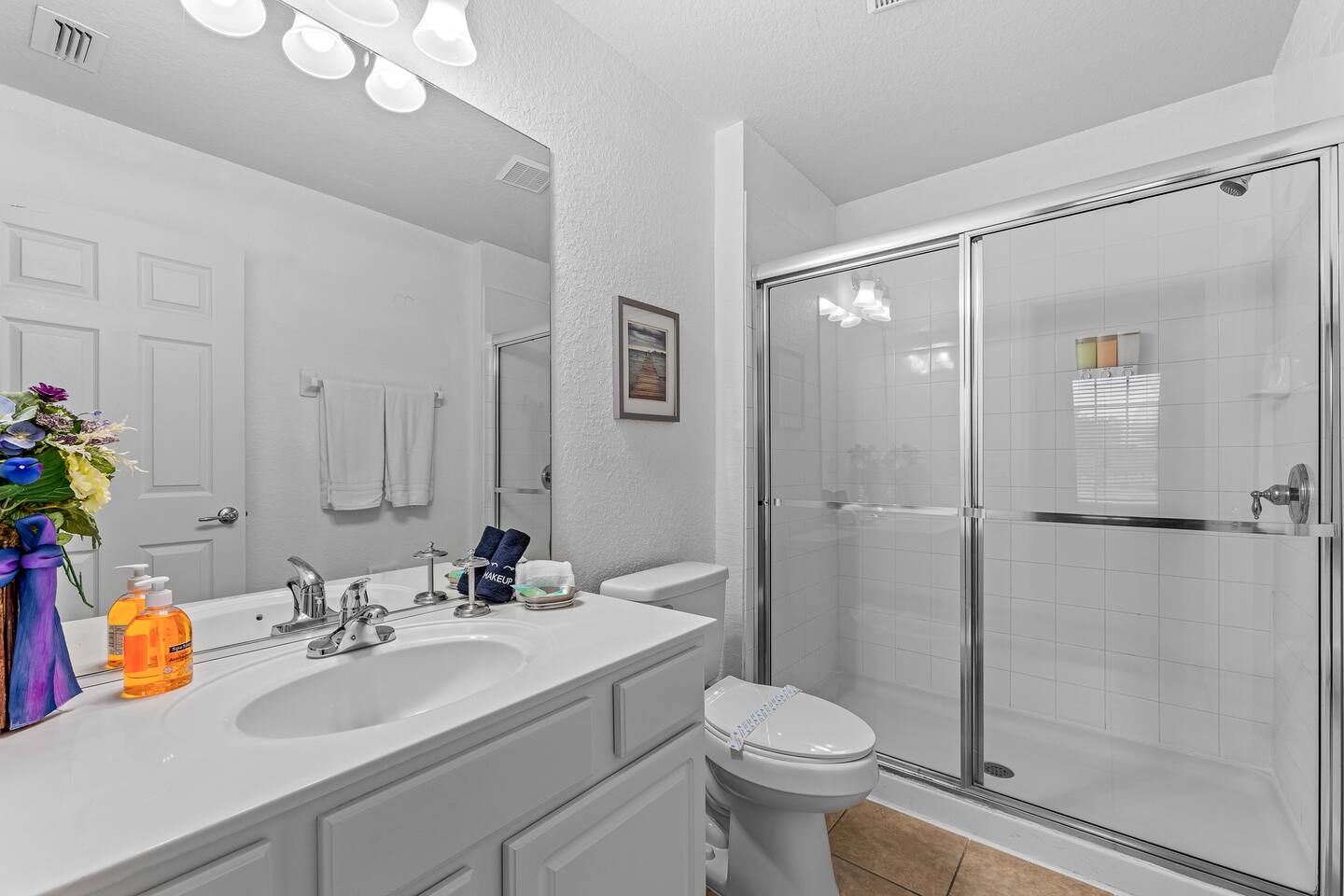 Bathroom with a glass walk-in shower and single vanity.