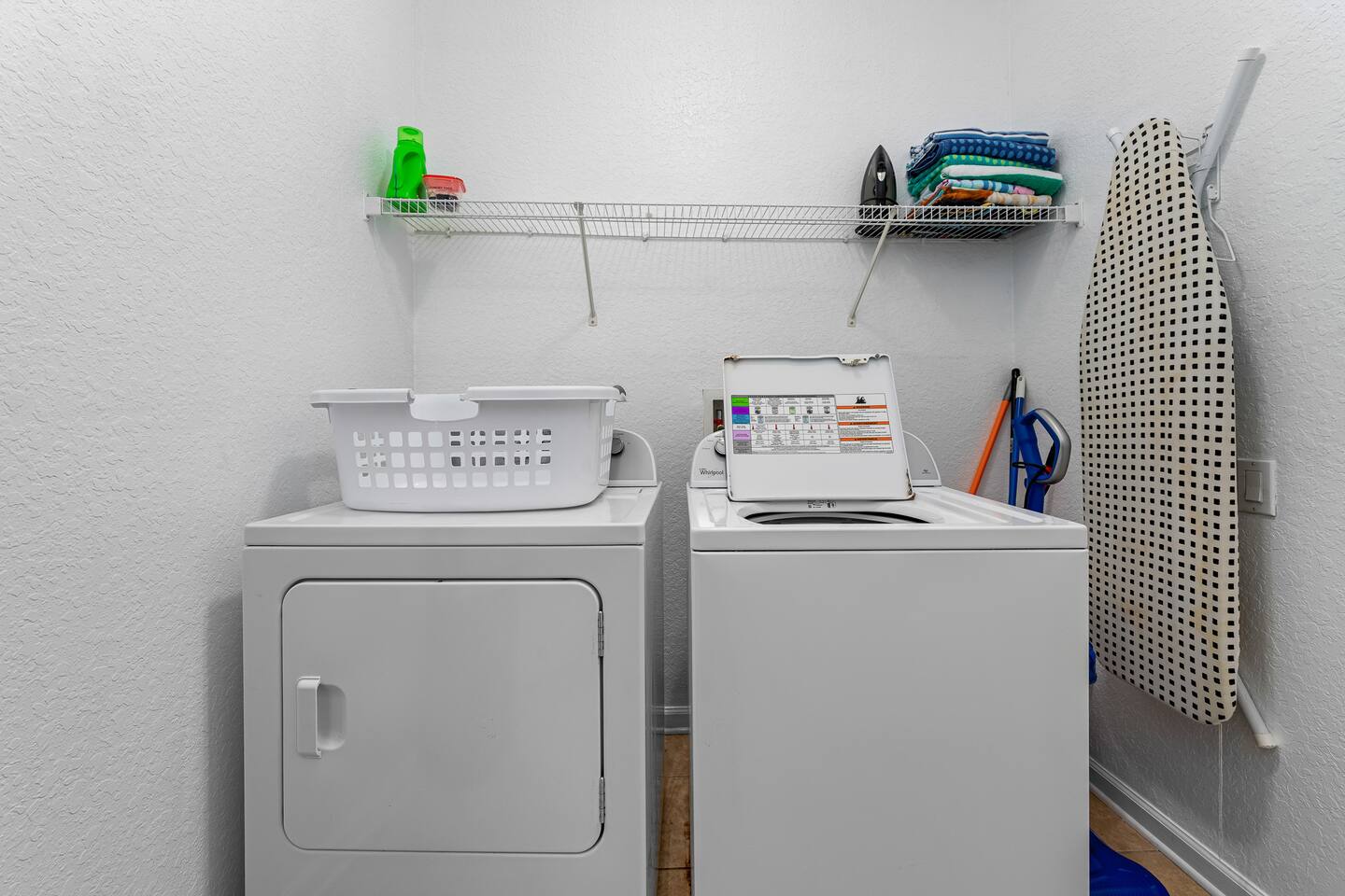 Laundry room with full-size washer, dryer, iron, and ironing board.