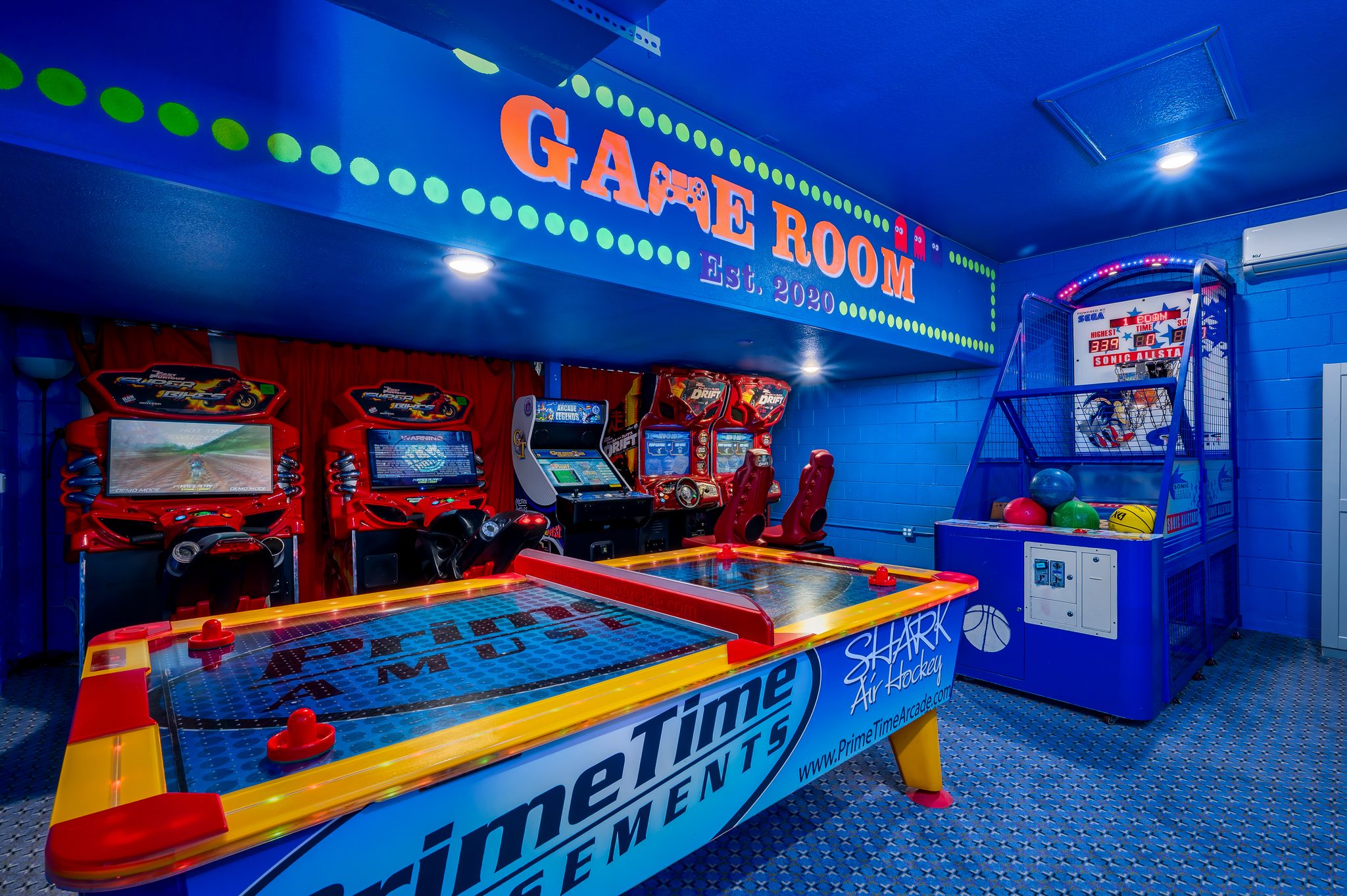 Colorful arcade game room: air hockey, racing simulators, and basketball