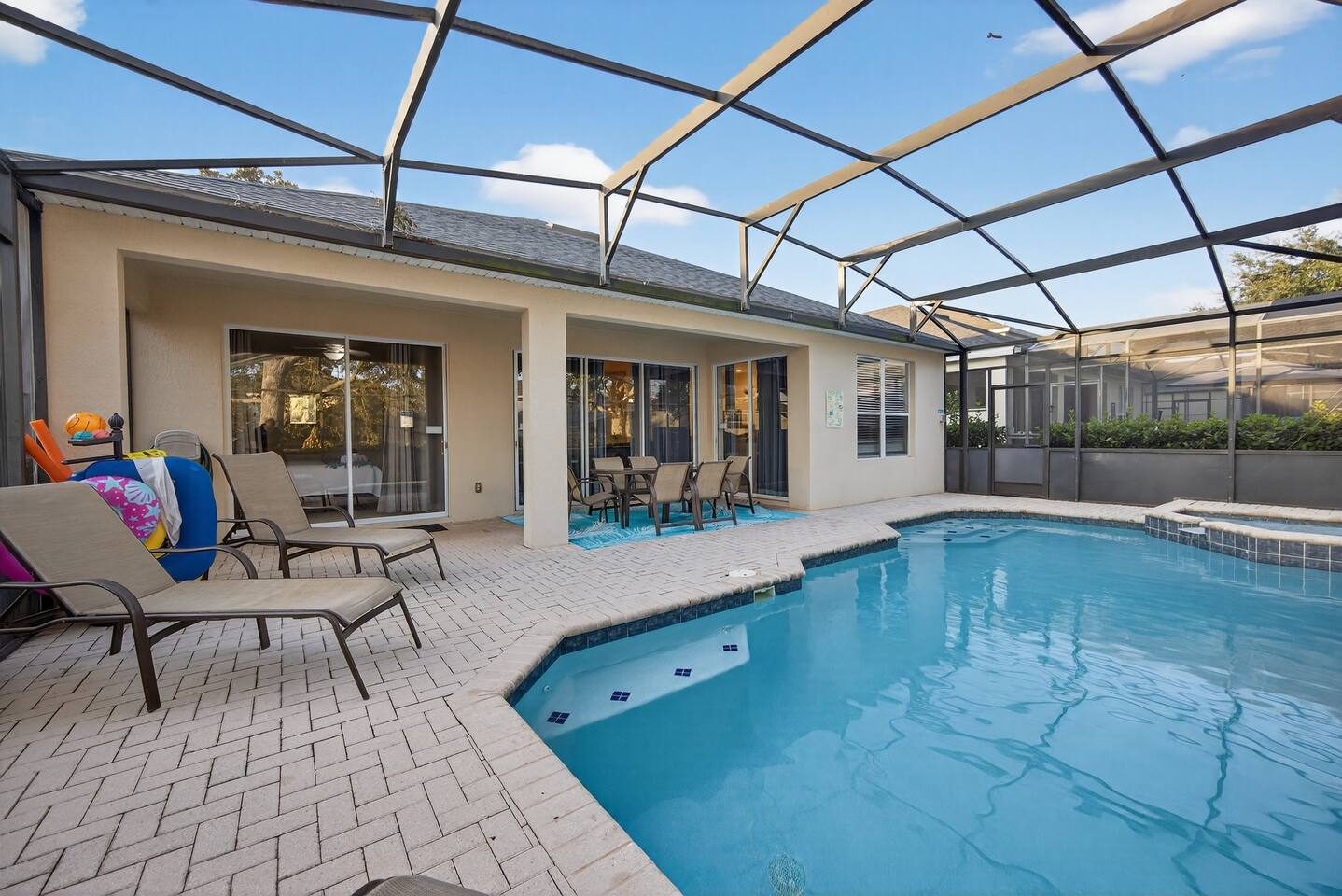 Screened private pool and spa with loungers and poolside toys