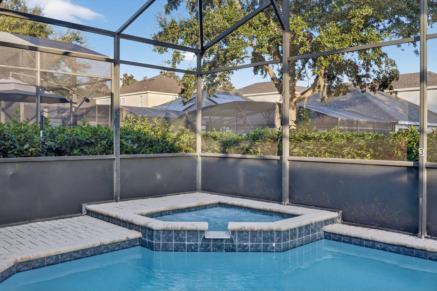 Tiled corner spa with spillover waterfall into the pool
