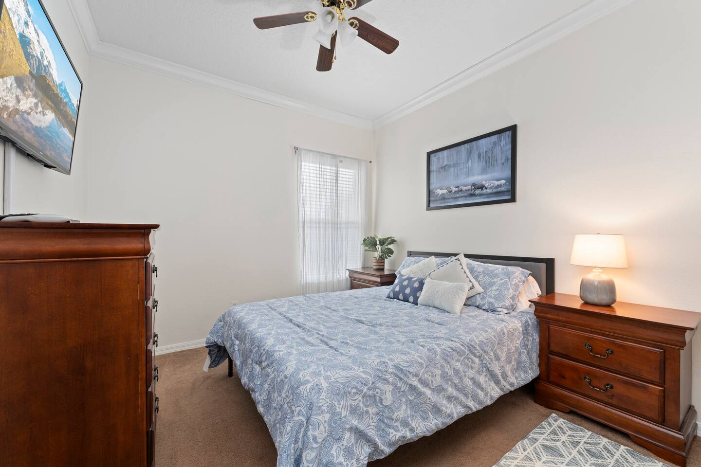 Tranquil space with plush bedding, vibrant decor, and flat-screen TV for relaxat