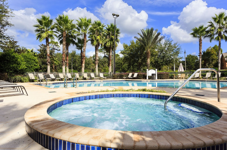 Bubbling community hot tub beside the resort pool, ringed by palms