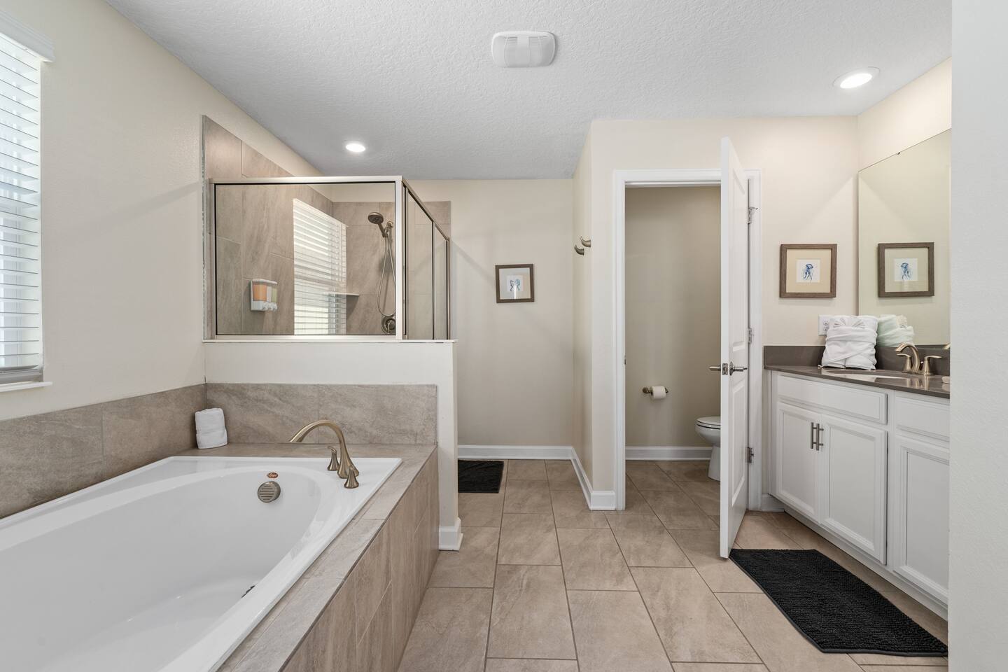 Master bathroom with soaking tub, glass shower, and private water closet