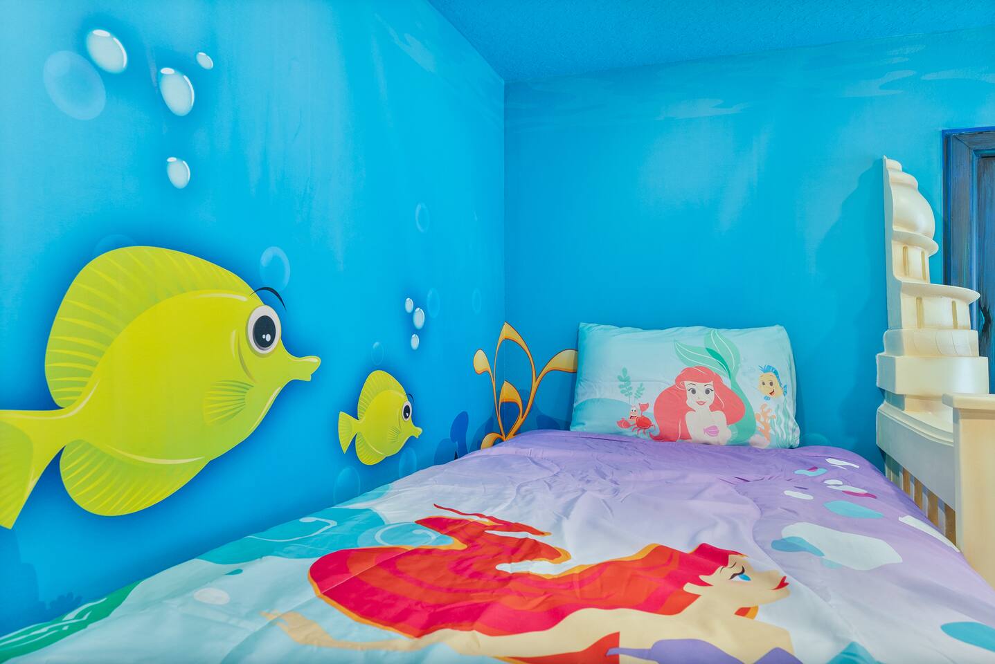 Little Mermaid room twin bed with mermaid bedding and tropical fish mural
