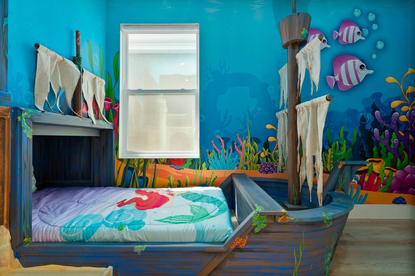 Pirate-ship twin bed beneath the window in the Little Mermaid room