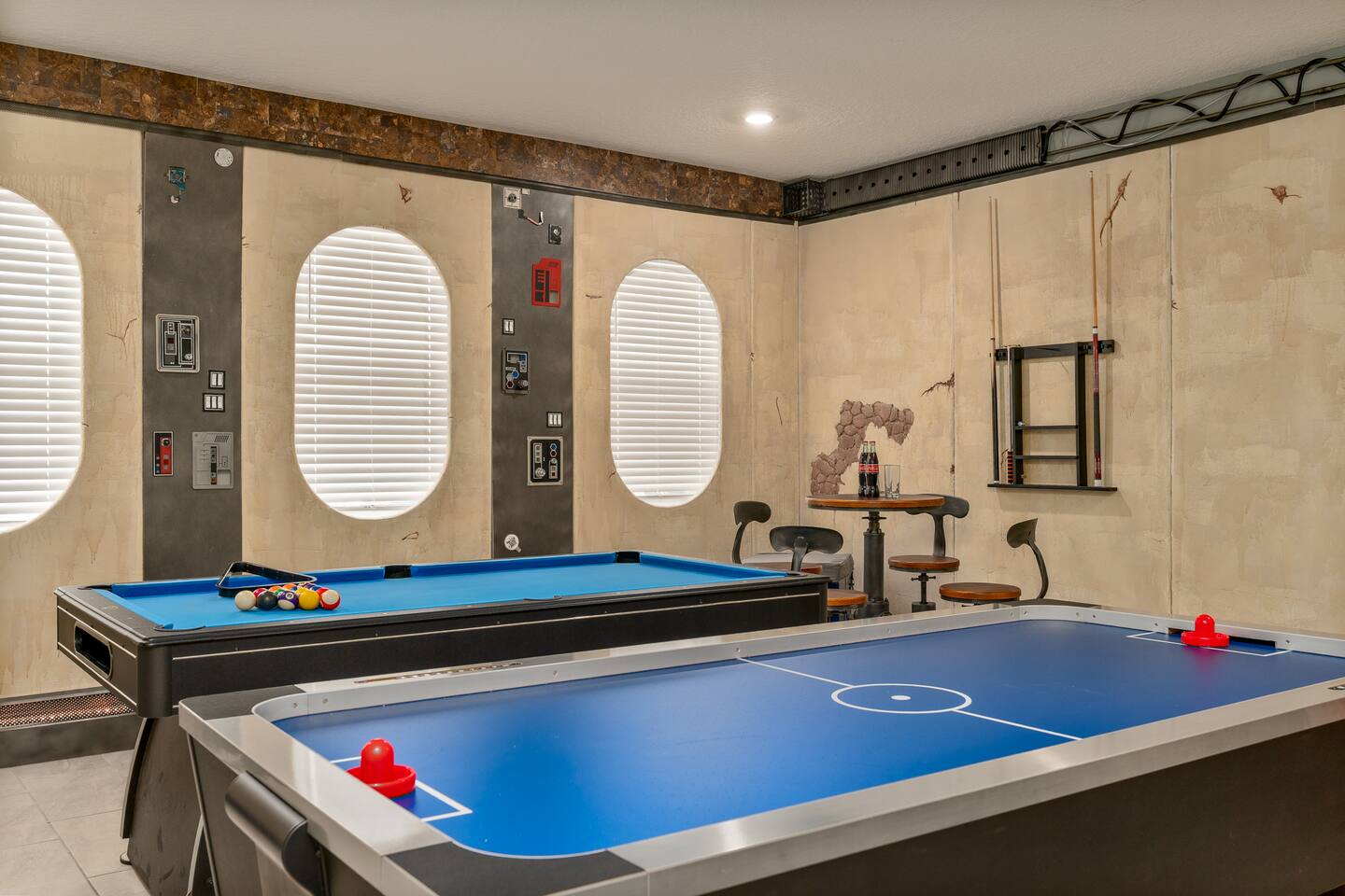 Game room with pool table, air hockey, porthole-style windows, and starship-pane