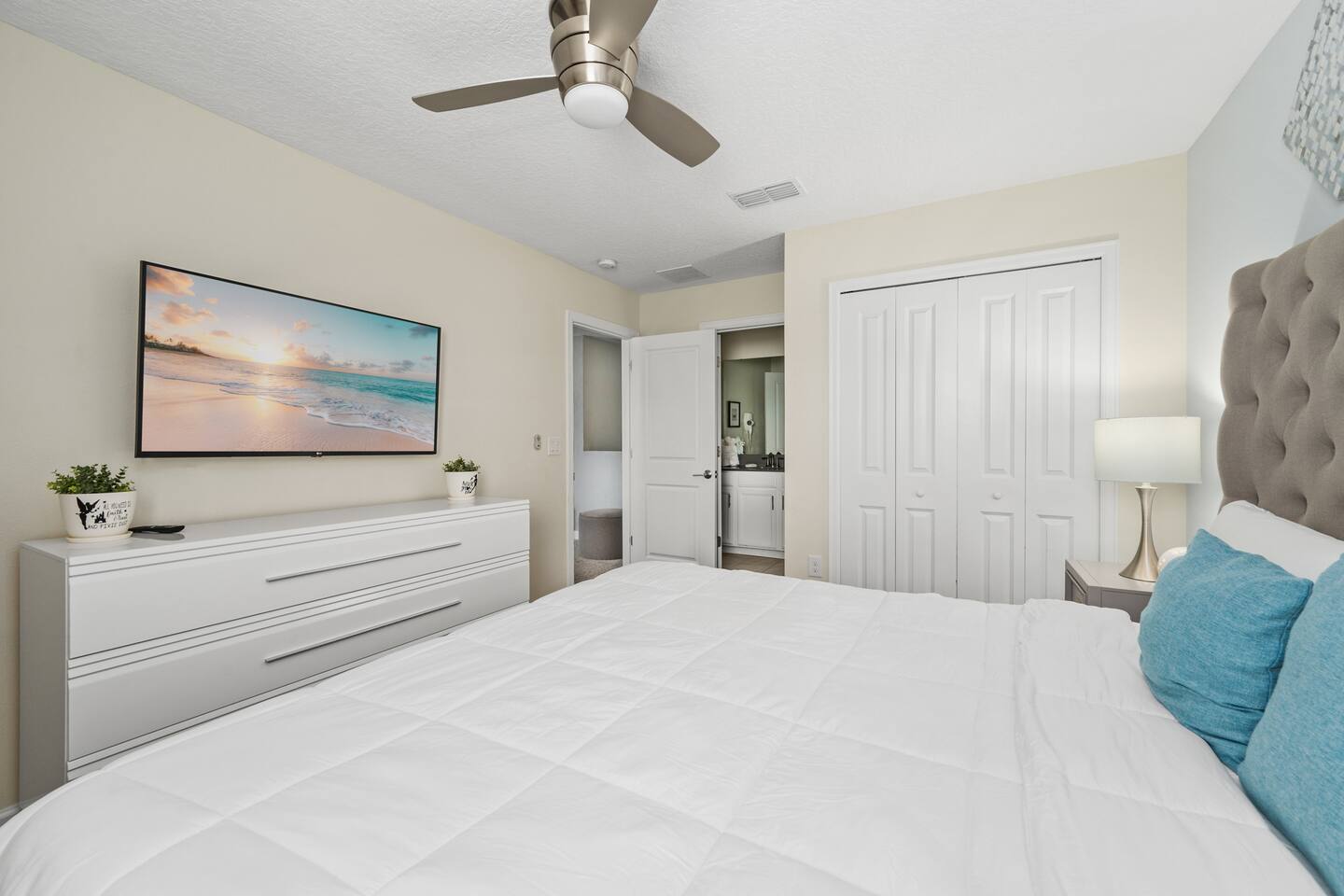 Two full beds with yellow accents in the main-floor bedroom off the kitchen
