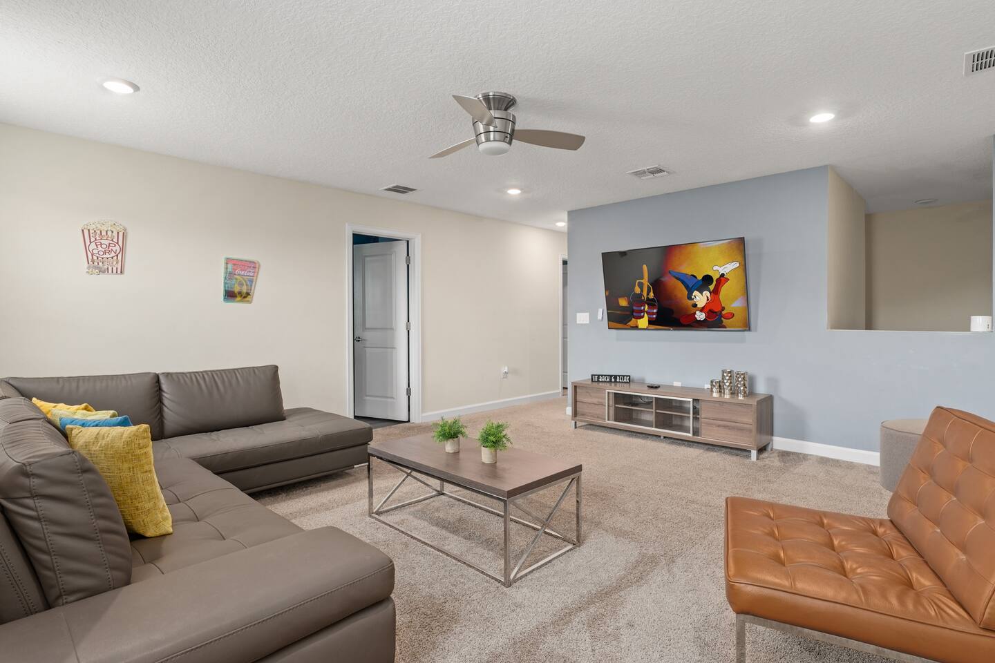 Upstairs loft lounge with sectional sofa and cinema-style popcorn decor