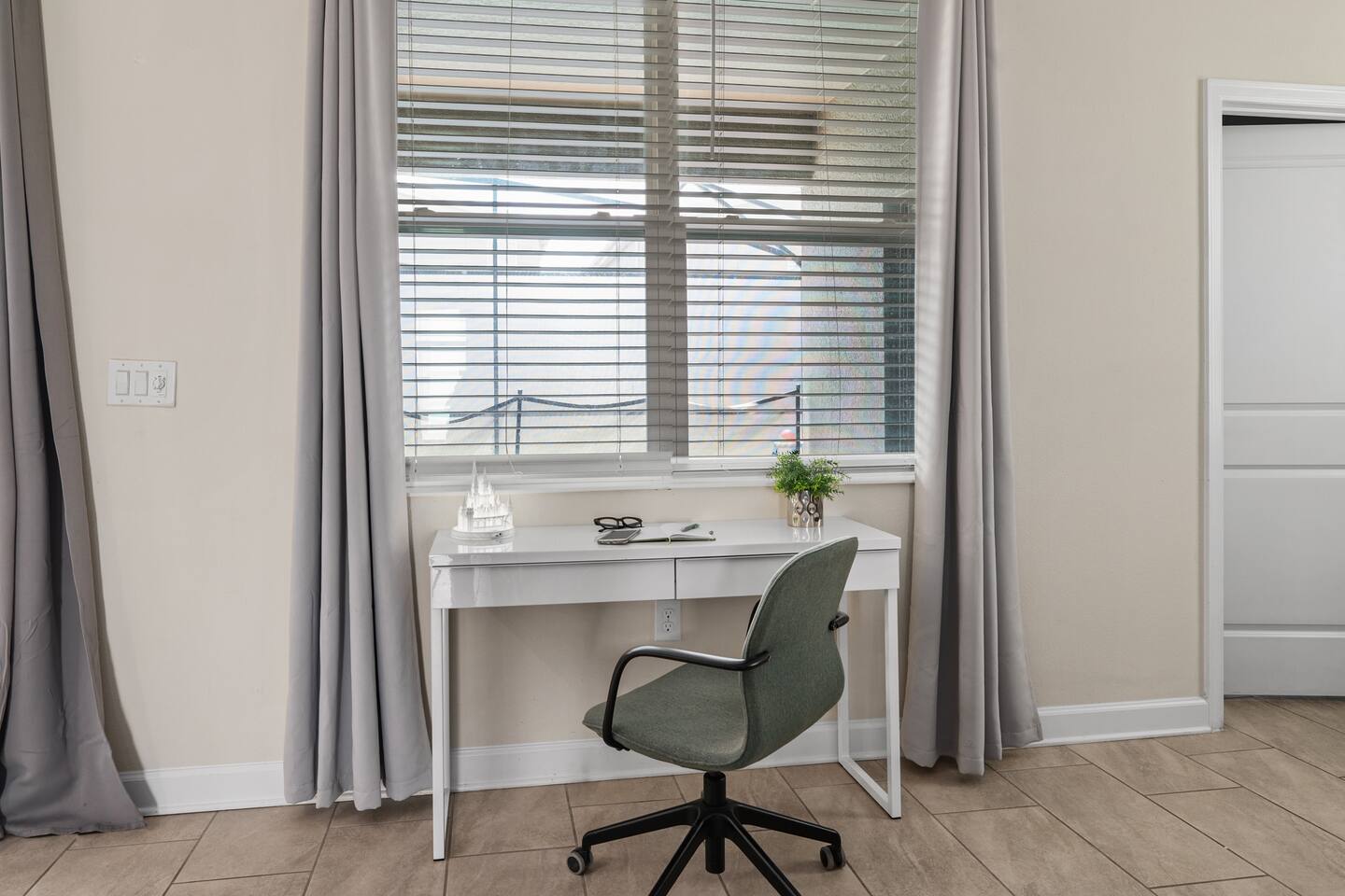 Desk workspace by the window with castle figurine and office chair