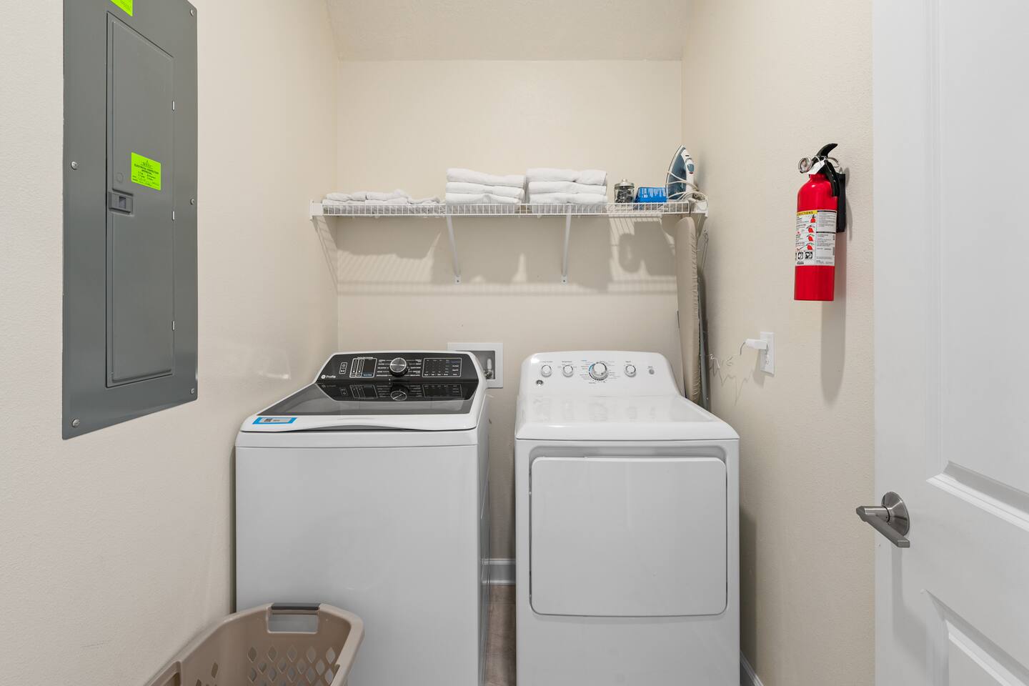 Laundry room with full-size washer and dryer, shelving, and iron