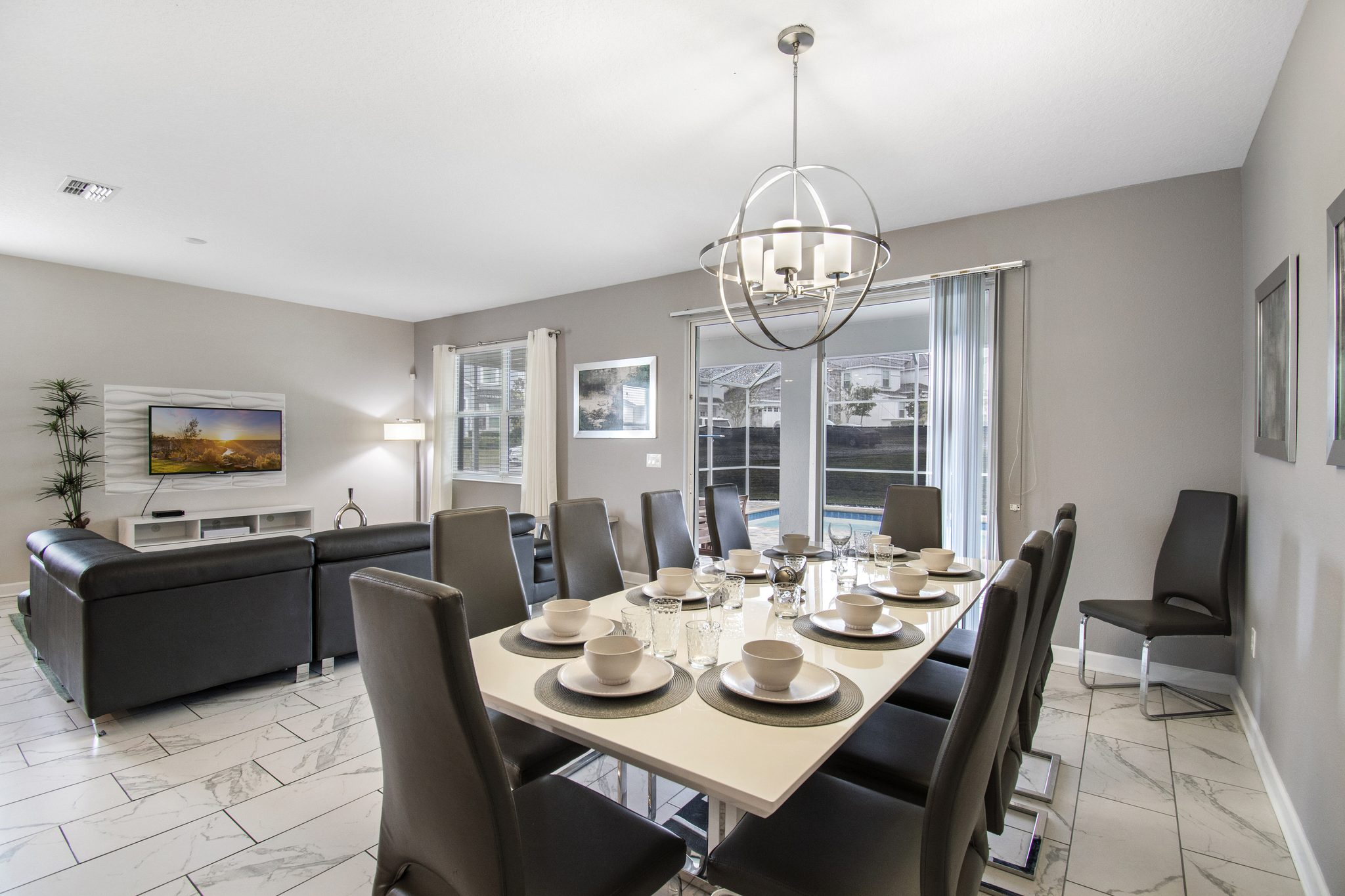 Dining table seating ten beside the living room, with sliding doors to the pool