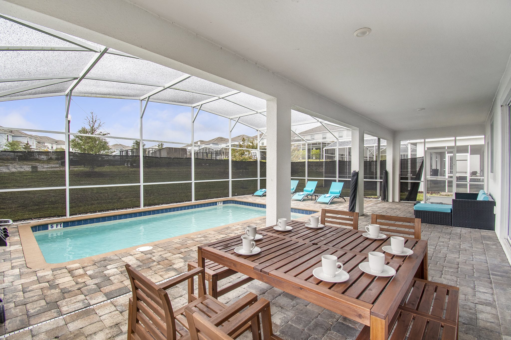 Covered lanai with a poolside dining table beside the screened private pool