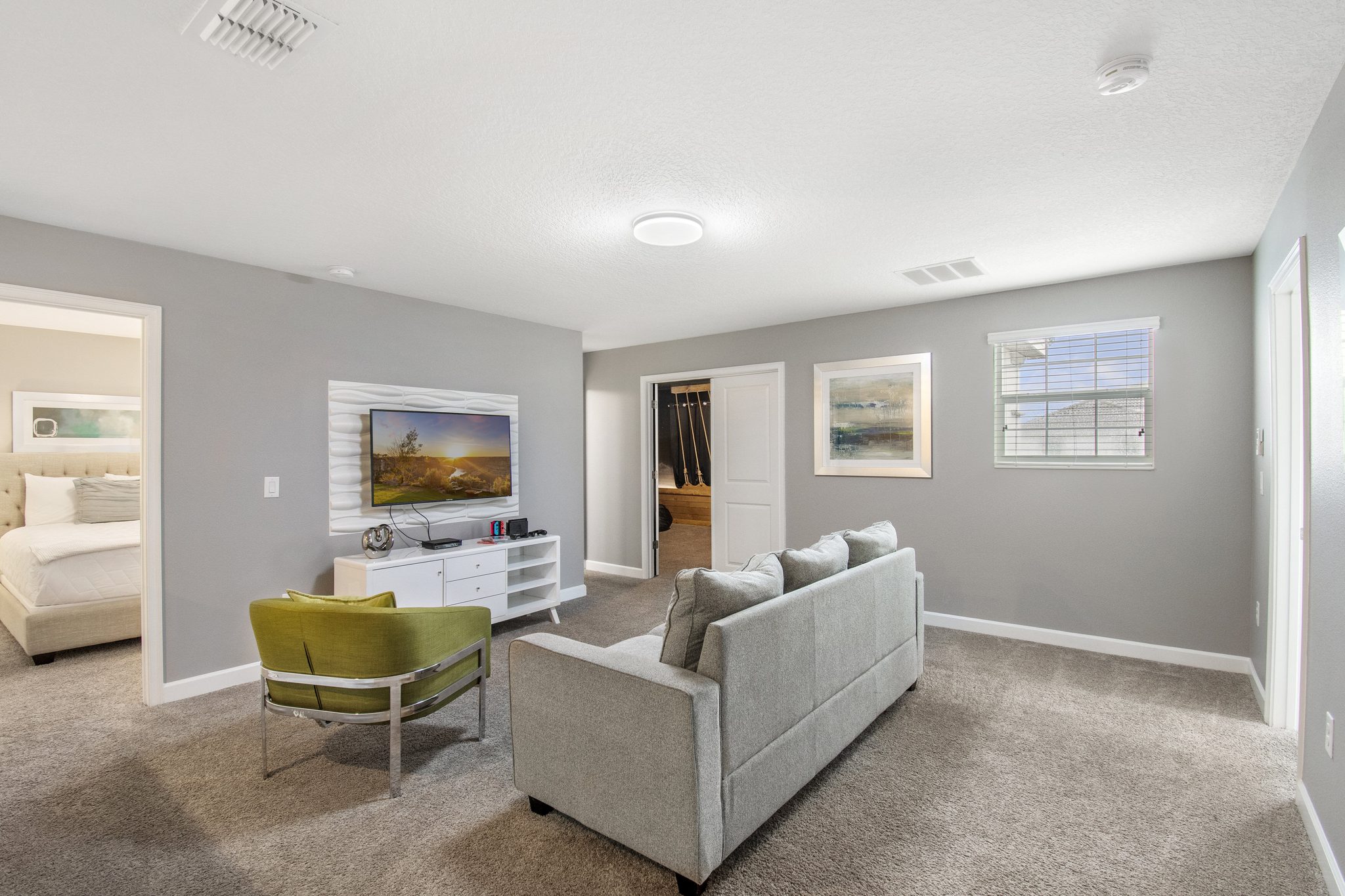 Upstairs loft lounge with a sofa, accent chair, and wall-mounted TV