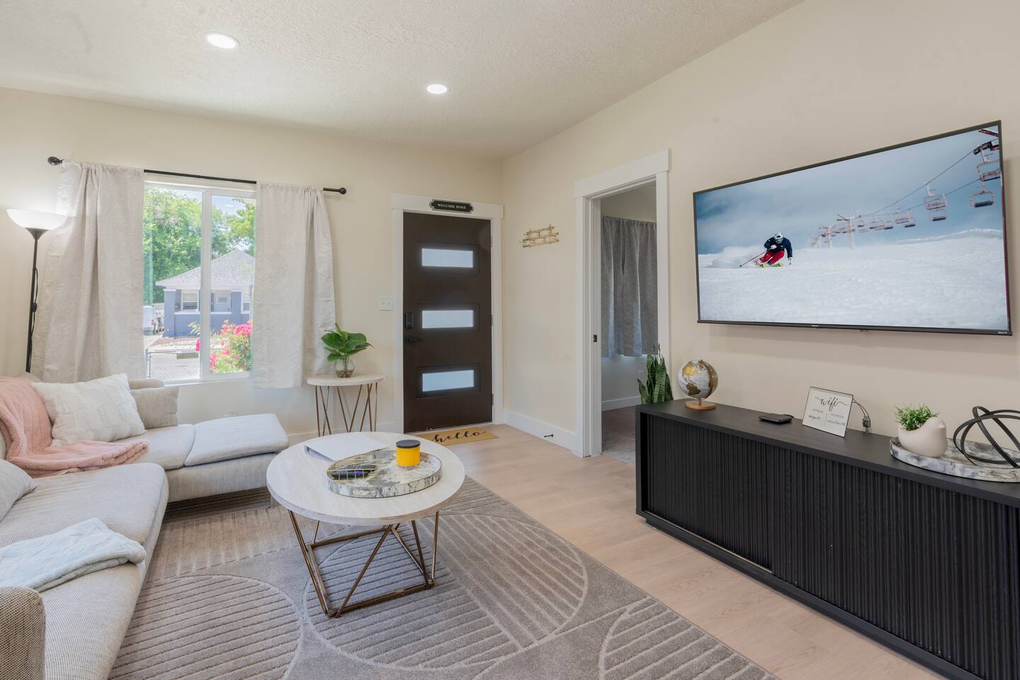 Living room with comfortable sectional seating and a wall-mounted smart TV for m