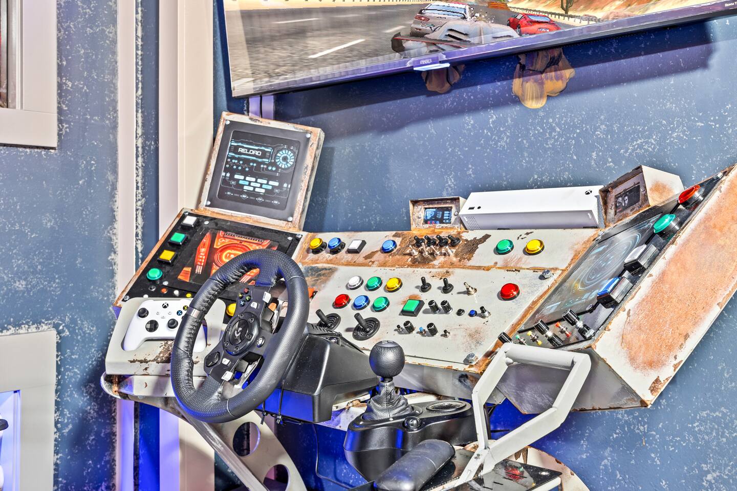Close-up of a racing simulator cockpit with steering wheel, gearshift, control p