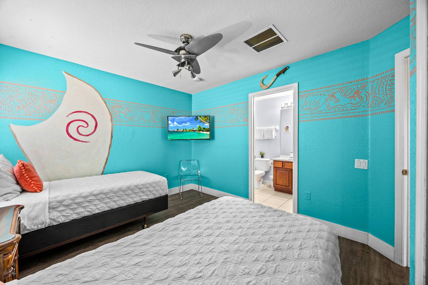 Moana-themed twin bedroom with two beds, en-suite bathroom access, and tropical 